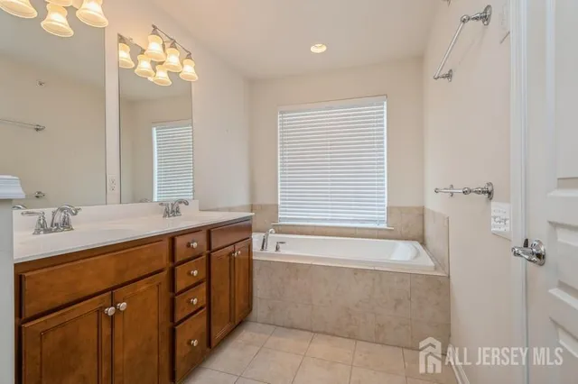 a bathroom with a tub sink and mirror