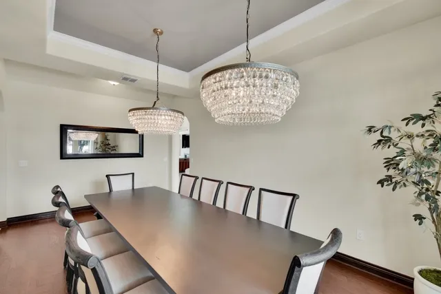 a view of a dining room with furniture a chandelier and wooden floor