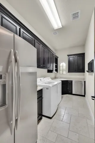 a kitchen with a sink refrigerator and cabinets
