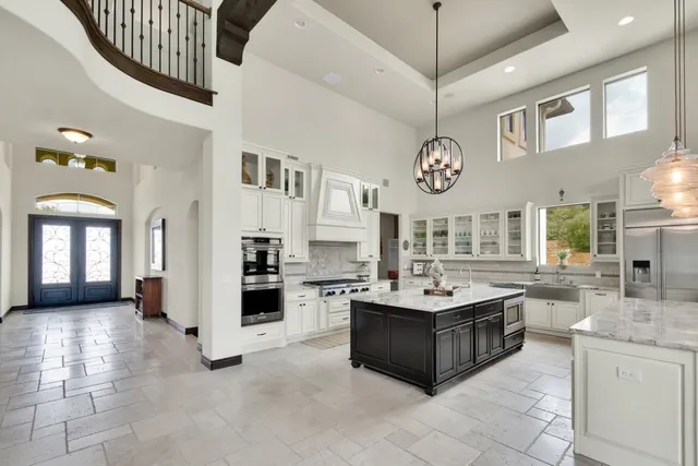 a kitchen with stainless steel appliances granite countertop a stove a sink and a refrigerator