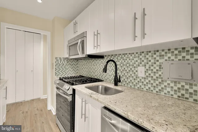 a kitchen with stainless steel appliances granite countertop a sink stove and cabinets