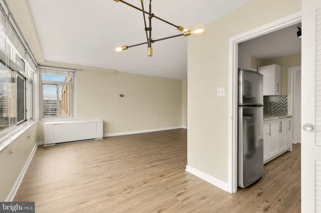 a view of a big room with wooden floor and windows