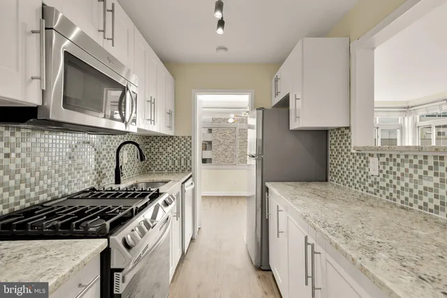 a kitchen with stainless steel appliances granite countertop a stove and a microwave