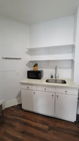 a kitchen with a sink and wooden floor