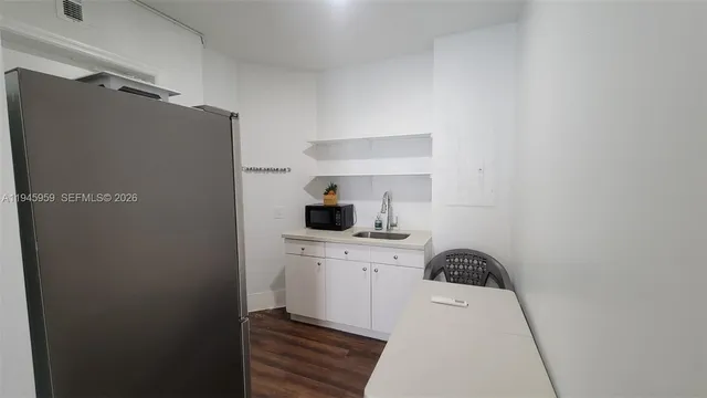 a kitchen with a refrigerator and cabinets