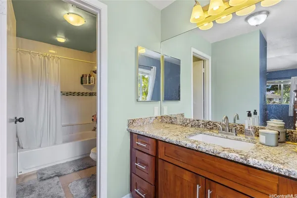 a bathroom with a granite countertop sink and a mirror
