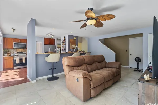 a living room with furniture a flat screen tv and kitchen view