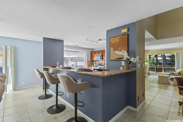 a dining hall with stainless steel appliances granite countertop a sink and a granite counter tops with a large window