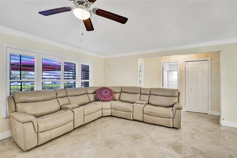 a living room with furniture and a ceiling fan
