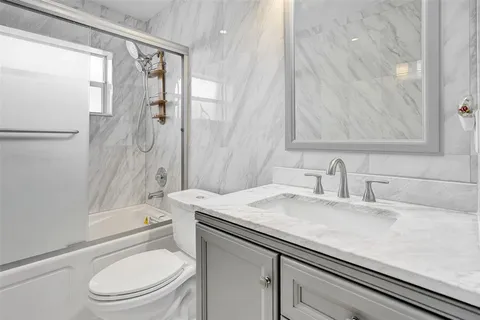 a bathroom with a sink toilet vanity and shower