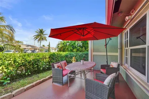 a view of a patio with table and chairs under an umbrella
