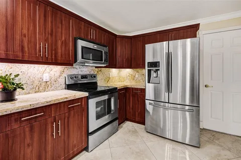 a kitchen with granite countertop a refrigerator stove and microwave