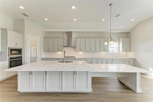 a large kitchen with kitchen island a sink stainless steel appliances and cabinets