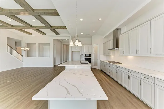 a large kitchen with kitchen island a sink stainless steel appliances and cabinets