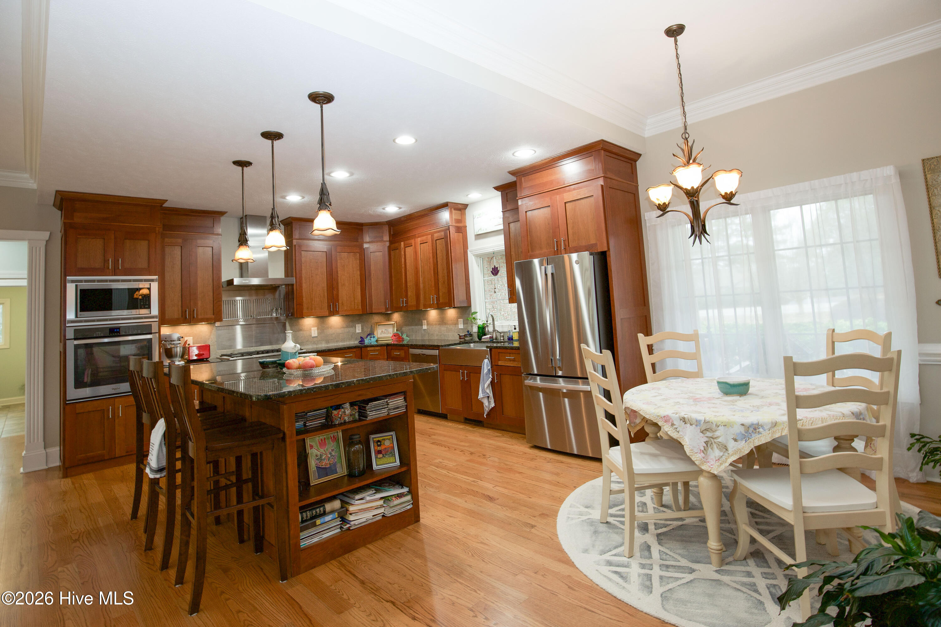 45 Richmond Road Jackson Springs, NC 27281 - Photo 17 of 93 Beautiful custom kitchen at 45 Richmond Rd featuring rich wood cabinetry, granite countertops, stainless steel appliances, and a spacious island with seating and built-in storage. The open layout flows seamlessly into a cozy breakfast nook bathed in natural light, perfect for casual dining and entertaining.