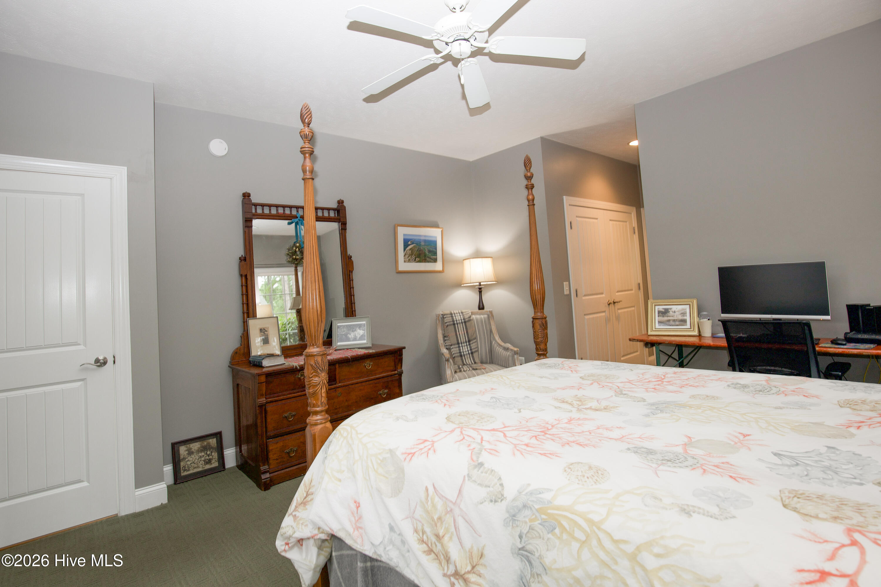 45 Richmond Road Jackson Springs, NC 27281 - Photo 29 of 93 This view of the primary bedroom highlights the built-in custom desk area, ideal for a home office setup or study nook. The room features soft gray walls, a ceiling fan, and plenty of natural light, offering a calm and functional retreat.