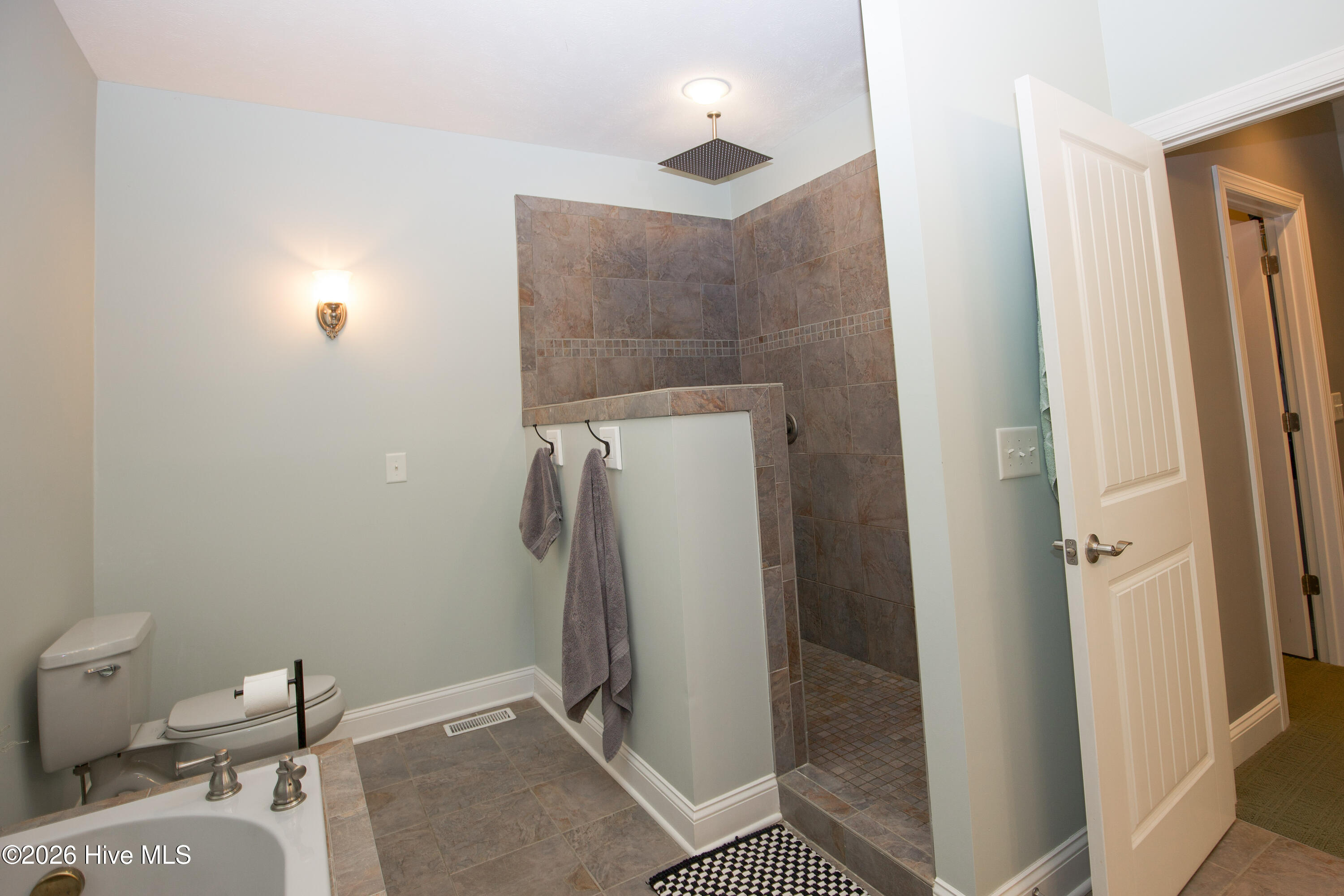 45 Richmond Road Jackson Springs, NC 27281 - Photo 40 of 93 The primary bathroom features a beautifully tiled, oversized walk-in shower with a rainfall showerhead, creating a spa-like experience. Thoughtful design elements and generous space make this a standout feature of the home.