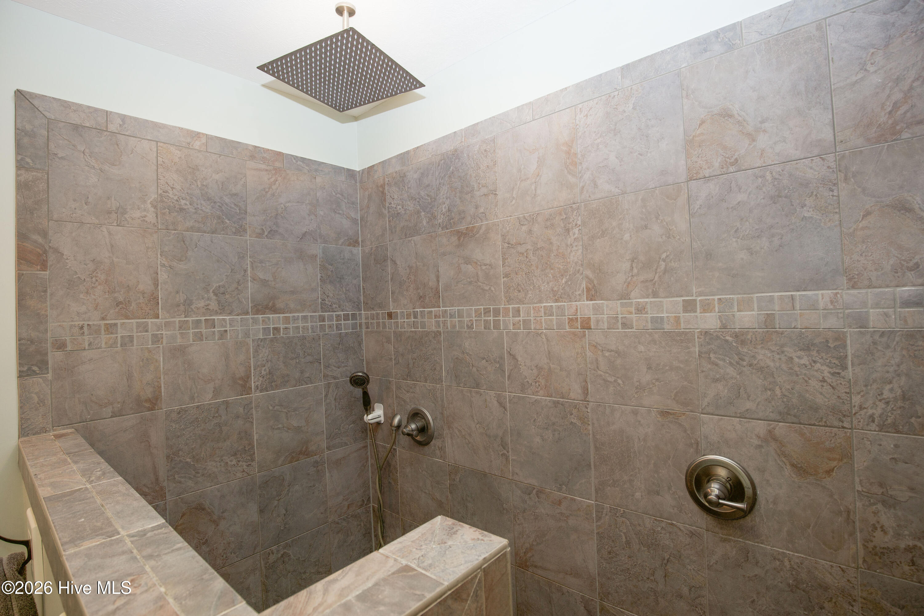 45 Richmond Road Jackson Springs, NC 27281 - Photo 42 of 93 Experience elevated comfort at 45 Richmond Road with this luxurious walk-in shower. Showcasing beautiful tile work, dual shower heads, including an oversized rainfall fixture, and thoughtful detailing, this spa-inspired feature is the centerpiece of the home's elegant primary bathroom.