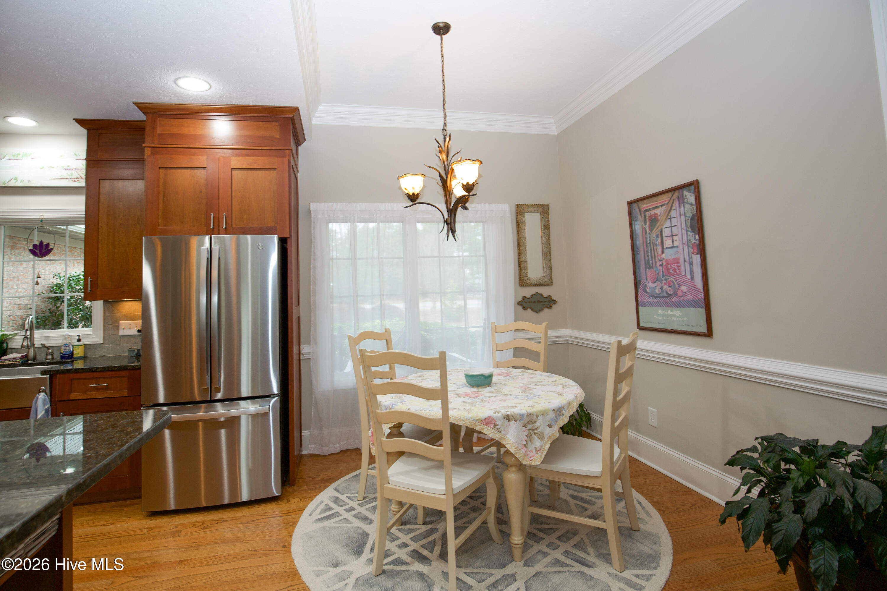 45 Richmond Road Jackson Springs, NC 27281 - Photo 48 of 93 Enjoy your morning coffee in this cozy breakfast nook, perfectly situated next to a large window that fills the space with natural light. Framed with elegant crown molding and wainscoting, this inviting corner features a stylish chandelier and easy access to the kitchen, making it ideal for casual dining and everyday meals.