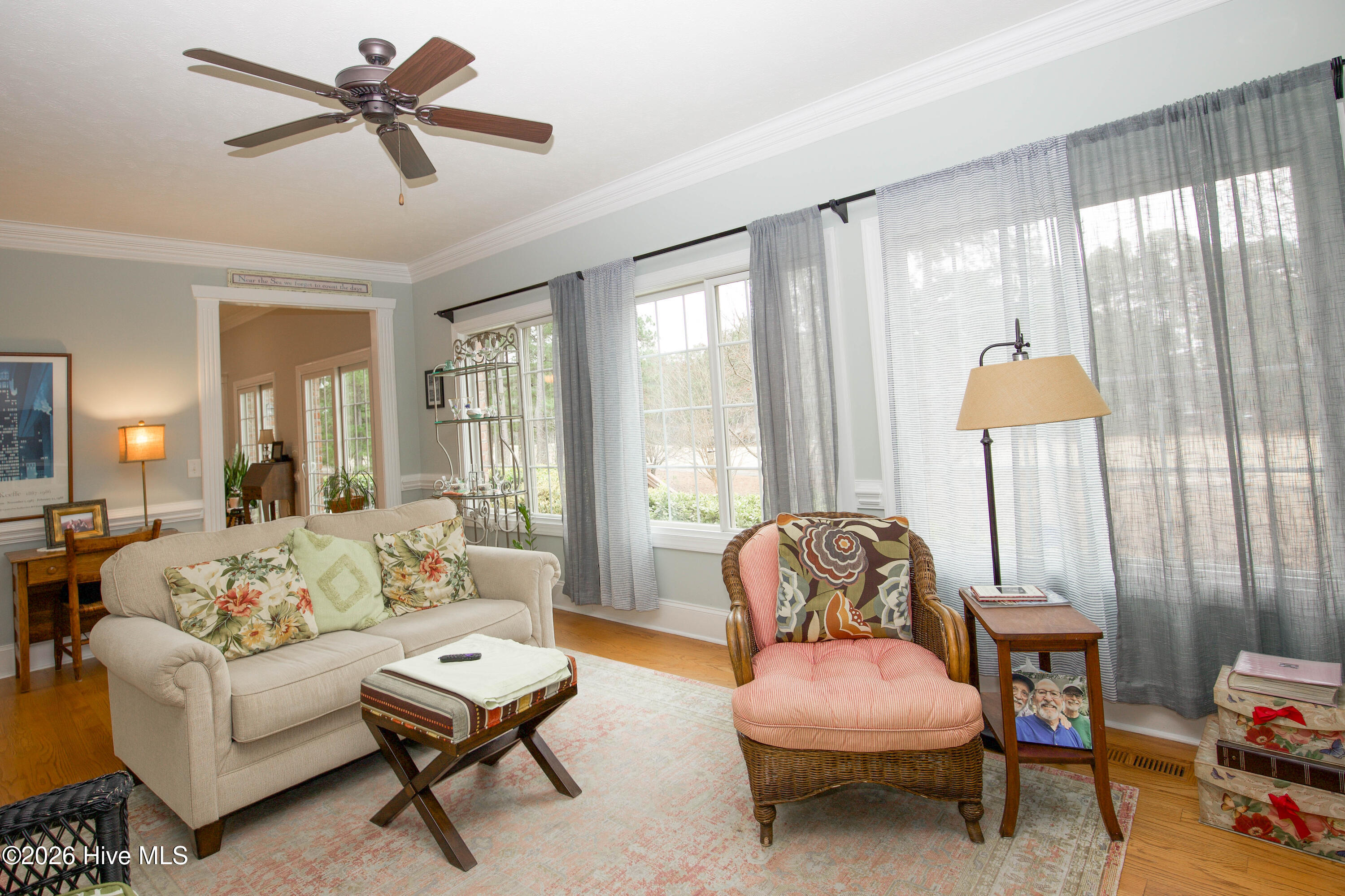 45 Richmond Road Jackson Springs, NC 27281 - Photo 51 of 93 This charming den offers the perfect blend of comfort and character. With large windows lining the wall, natural light pours in, highlighting the warm hardwood floors and crown molding. The space is anchored by custom built-in shelving—ideal for books, art, or personal treasures. A soft color palette enhances the room's inviting atmosphere, while thoughtful touches like detailed trim work and a ceiling fan add classic appeal. Whether you're curling up with a book, entertaining guests, or simply enjoying a peaceful afternoon, this versatile room offers a welcoming retreat in the heart of the home.