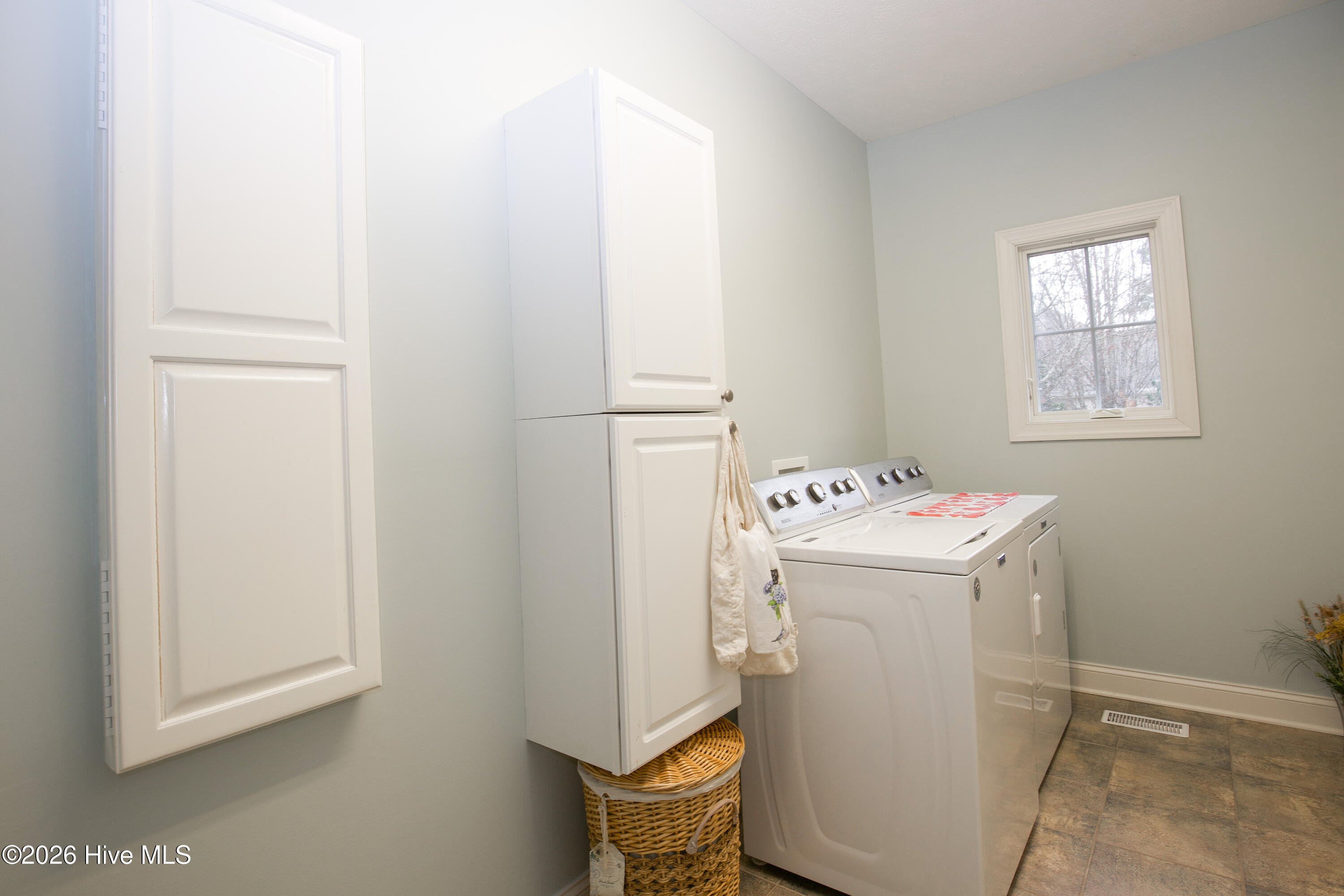 45 Richmond Road Jackson Springs, NC 27281 - Photo 55 of 93 This well-organized laundry room offers both functionality and style. Featuring a large window for natural light, it includes a side-by-side washer and dryer, generous cabinet storage above and alongside for all your laundry essentials, and a neutral tile floor that’s as durable as it is easy to clean. A bright and practical space designed to streamline your day-to-day tasks.