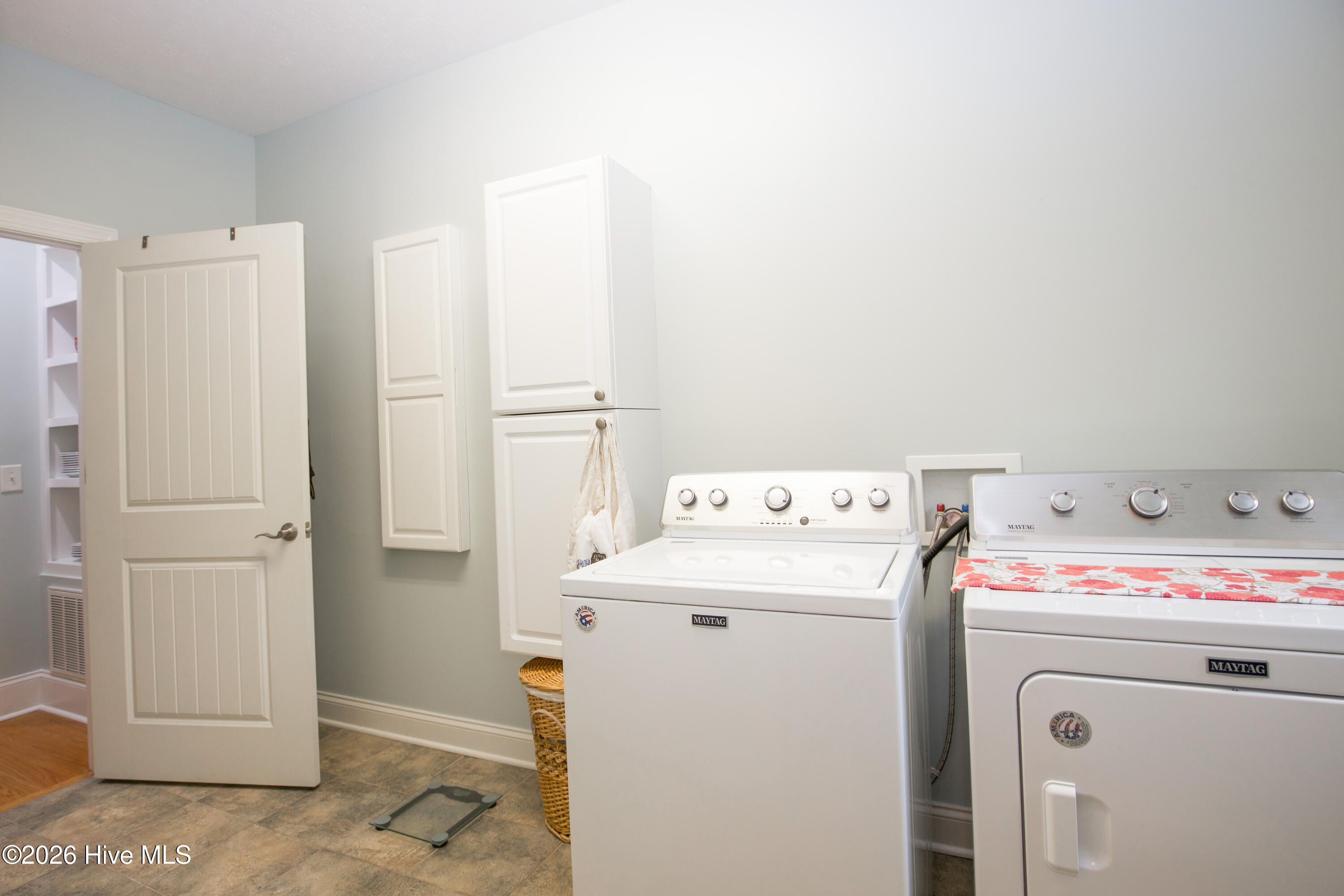 45 Richmond Road Jackson Springs, NC 27281 - Photo 56 of 93 This well-appointed laundry room features a full-size washer and dryer set, surrounded by ample built-in cabinetry for convenient storage. The neutral wall color and durable tile flooring create a clean, functional space with room to sort, fold, and organize. Located just off the main hallway, it offers easy access while maintaining separation from main living areas.