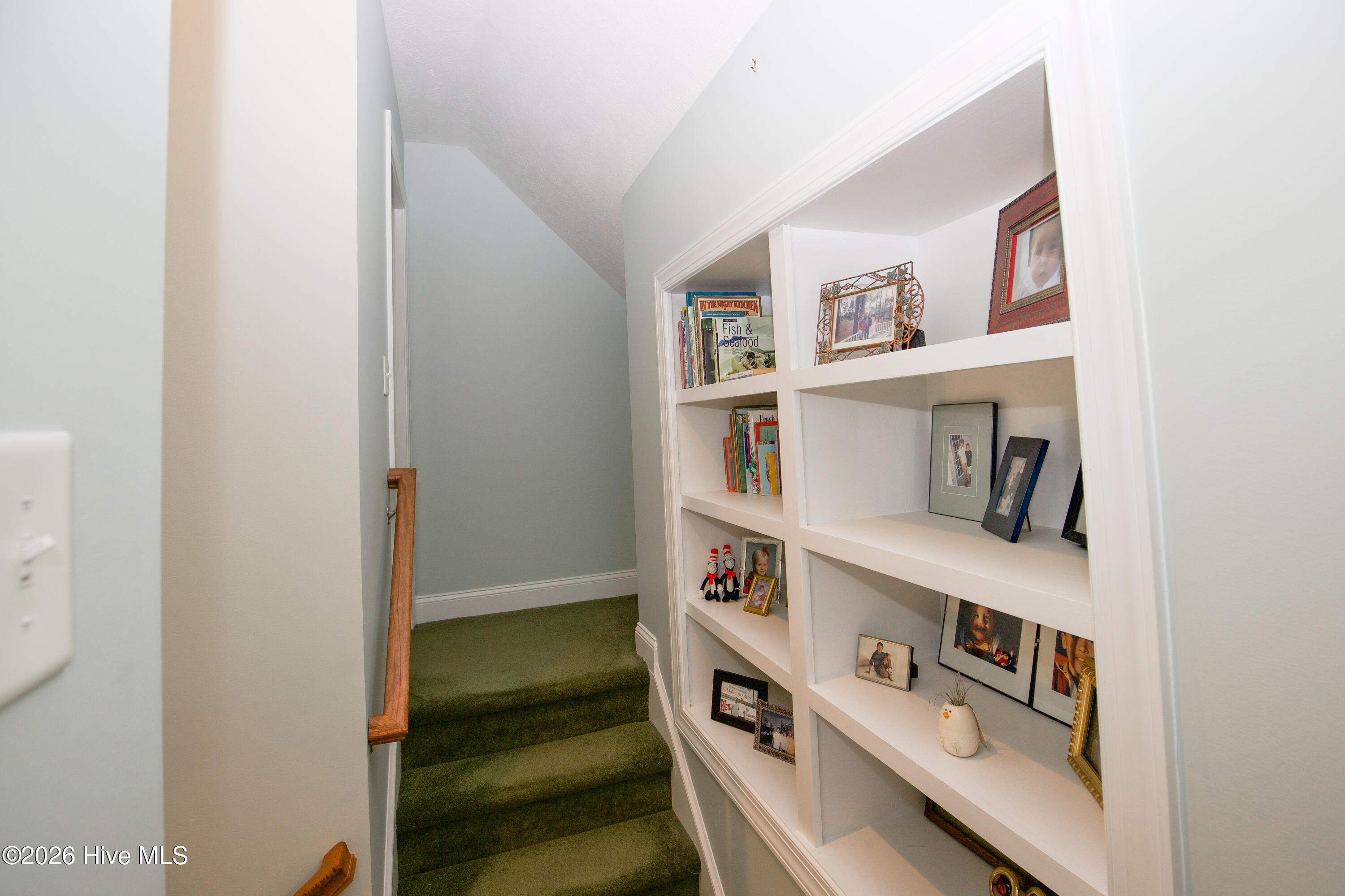 45 Richmond Road Jackson Springs, NC 27281 - Photo 58 of 93 At the top of the staircase, the upstairs landing offers a cozy, personal touch with built-in shelving that’s perfect for books, family photos, and meaningful keepsakes. The thoughtful design of this niche area creates a warm, inviting transition to the second floor, blending functionality with character and charm.