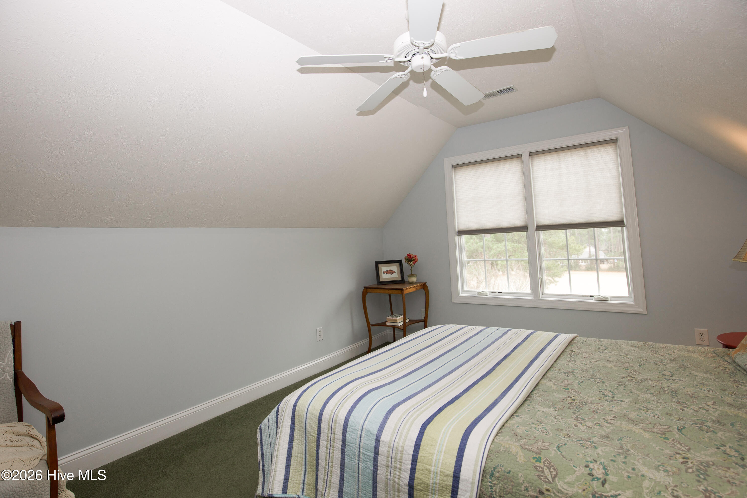 45 Richmond Road Jackson Springs, NC 27281 - Photo 61 of 93 Tucked upstairs for added privacy, this spacious bedroom offers a peaceful retreat with a vaulted ceiling, soft natural light, and a charming alcove window. The versatile layout makes it ideal as a guest suite, home office, or cozy additional bedroom, perfect for accommodating a variety of needs.