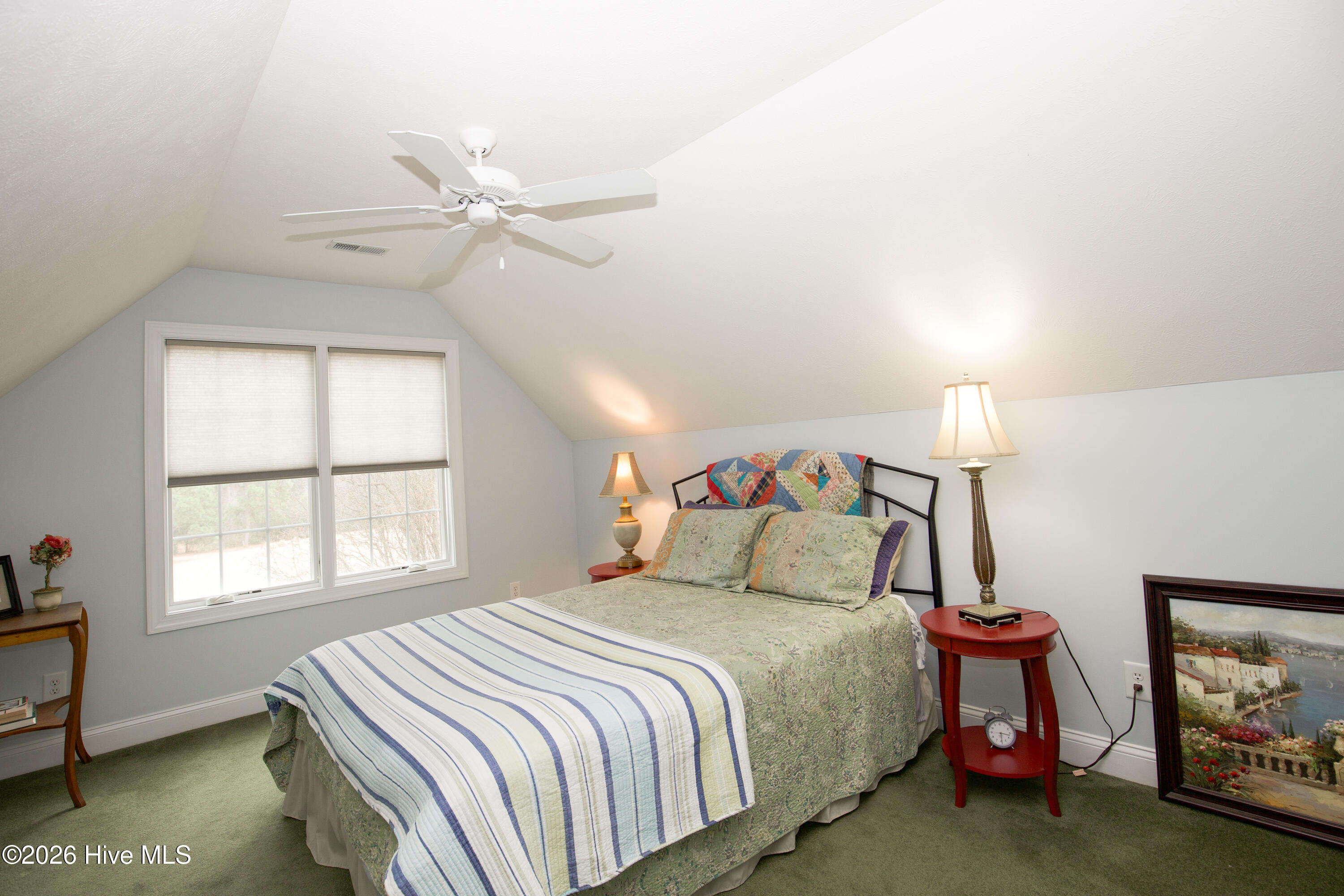 45 Richmond Road Jackson Springs, NC 27281 - Photo 62 of 93 Tucked beneath charming sloped ceilings, this upstairs bedroom at 45 Richmond Rd offers a quiet, inviting retreat. Natural light pours in through double windows, enhancing the sense of warmth and comfort. With ample space for a bed, nightstands, and a reading nook or small desk, it’s ideal for guests, a home office, or a tranquil personal escape.