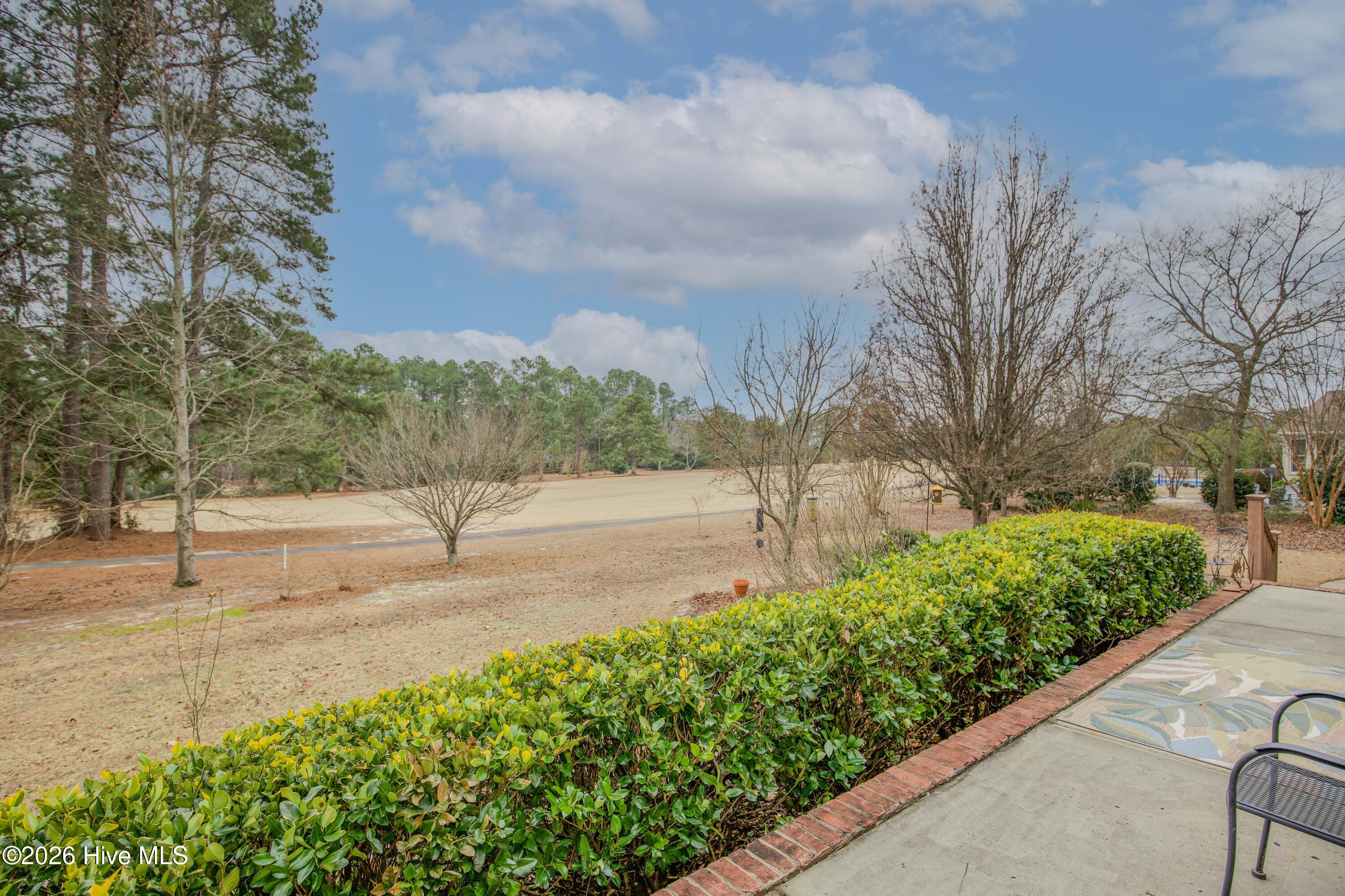 45 Richmond Road Jackson Springs, NC 27281 - Photo 74 of 93 Enjoy expansive golf course views right from your back patio at 45 Richmond Rd. This inviting outdoor space offers a peaceful vantage point of the Red Fox Golf Course, surrounded by mature trees and manicured hedges for added privacy. Whether you're sipping coffee in the morning or entertaining guests in the evening, this patio provides a serene and picturesque setting to savor the beauty of your surroundings.