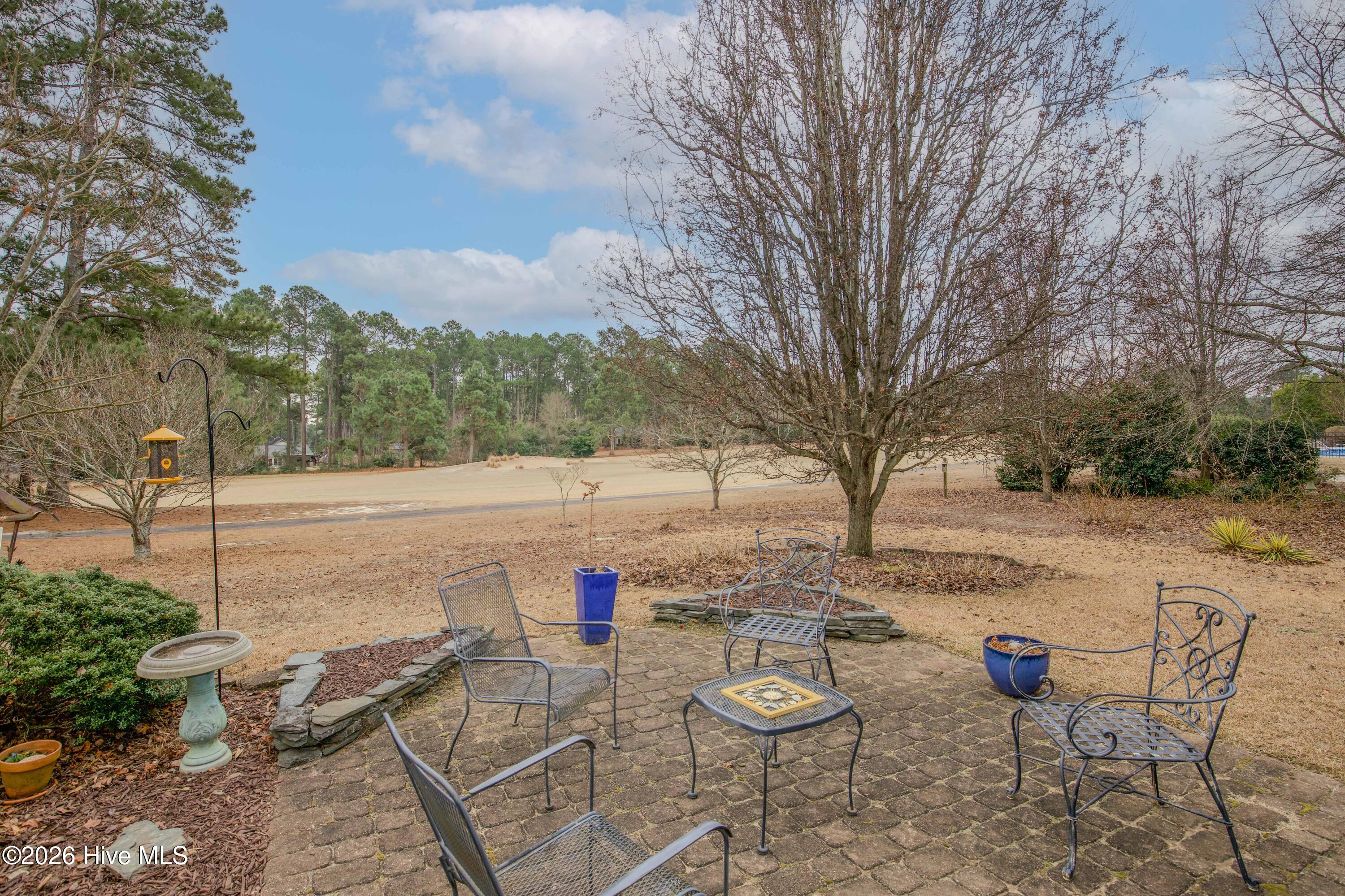 45 Richmond Road Jackson Springs, NC 27281 - Photo 78 of 93 Enjoy serene mornings or peaceful evenings on this charming back patio with sweeping views of the Red Fox golf course. Surrounded by nature and mature landscaping, this space is perfect for relaxing, entertaining, or watching the golfers pass by.