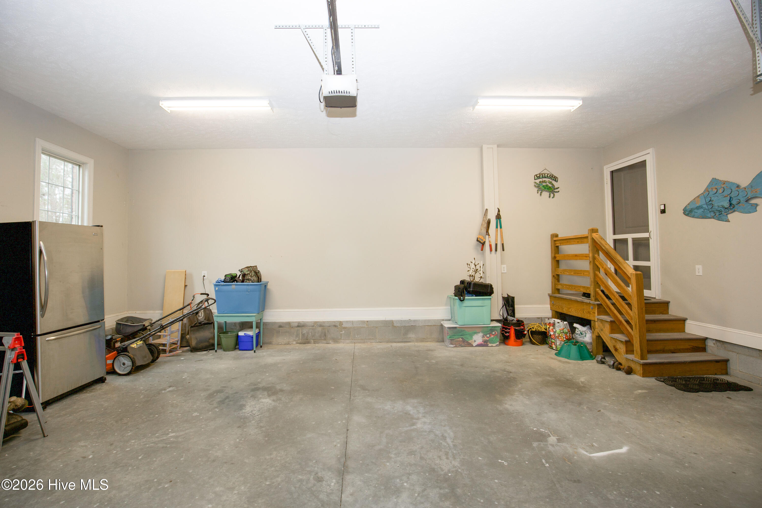 45 Richmond Road Jackson Springs, NC 27281 - Photo 92 of 93 This oversized two-car garage offers a clean, well-lit space with finished walls, high ceilings, and a durable concrete floor. With built-in stairs leading directly into the home and plenty of room for storage, tools, and equipment—including space for a second refrigerator—this garage provides both functionality and convenience for everyday living.