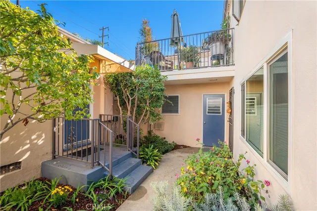 a view of a house with fountain and potted plants