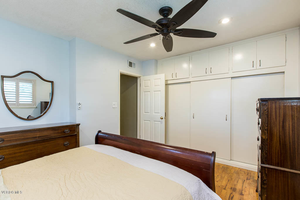 4238 Adam Road Simi Valley, CA 93063 - Photo 14 of 35 a bedroom with a bed a mirror and a chandelier