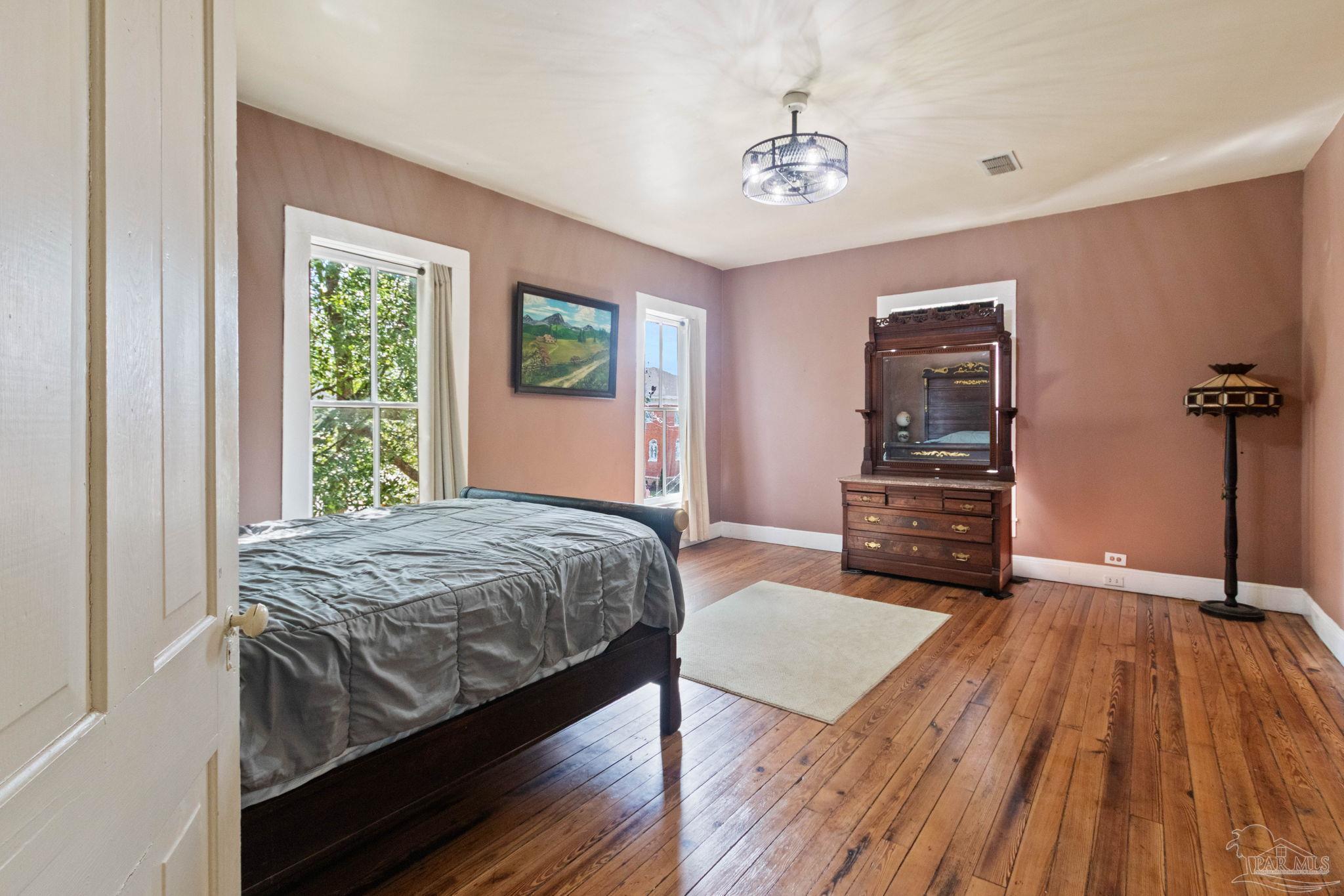 309 South Main Street Atmore, AL 36502 - Photo 27 of 47 a bedroom with a bed and a chandelier