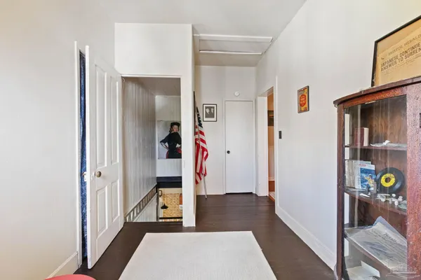 a view of hallway with wooden floor and bedroom