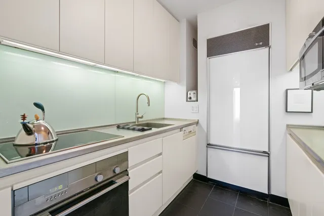 a kitchen with a refrigerator sink and cabinets