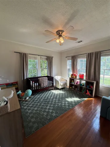 a bed sitting in a spacious bedroom next to a window