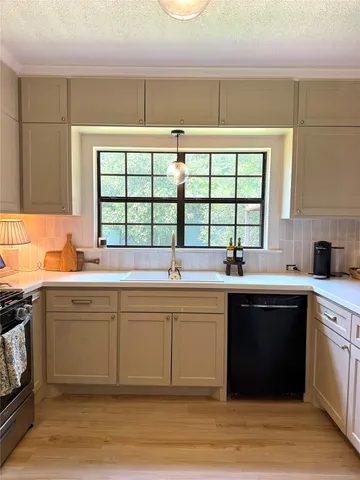 a kitchen with stainless steel appliances a stove a sink and white cabinets