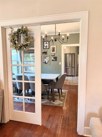a spacious bedroom with a bed a chandelier and mirror
