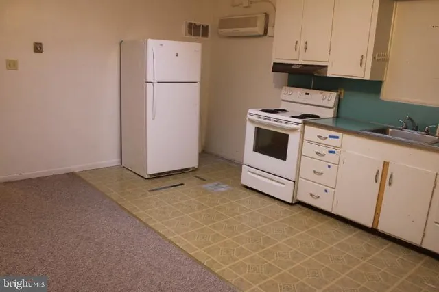 a kitchen with white cabinets and white appliances