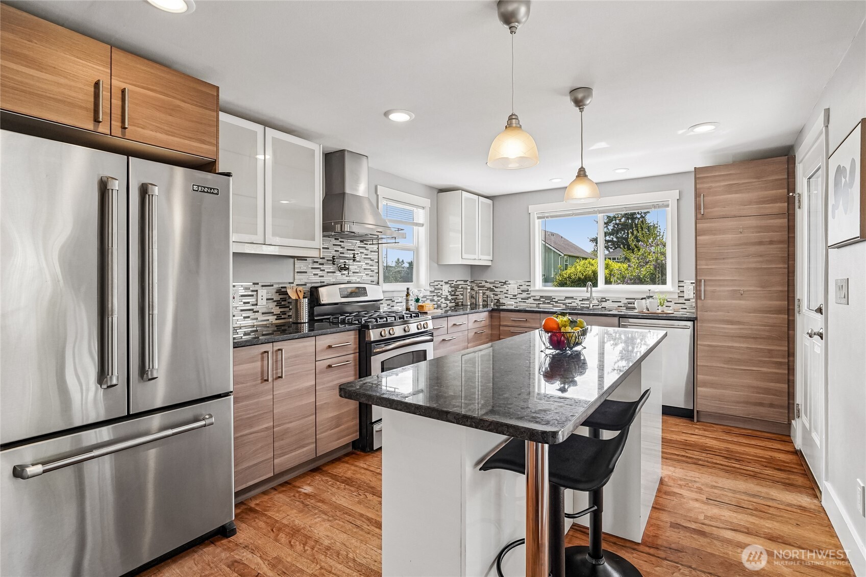 7313 25th Avenue Northwest Seattle, WA 98117 - Photo 8 of 40 a kitchen with stainless steel appliances granite countertop a refrigerator a sink dishwasher a stove and white countertops with wooden floor