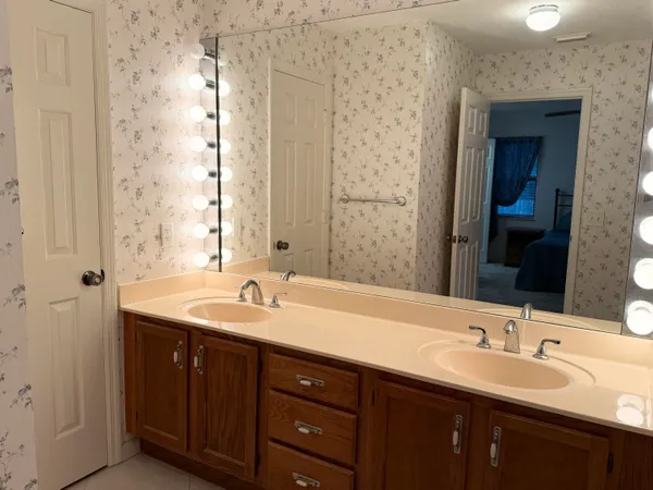 a bathroom with double sink and a mirror