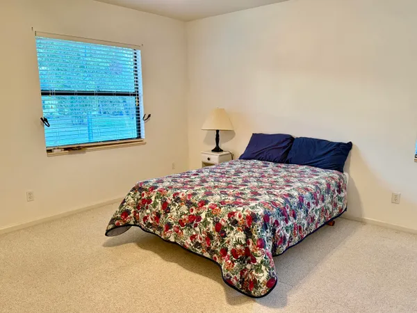 a bed sitting in a bedroom next to a window