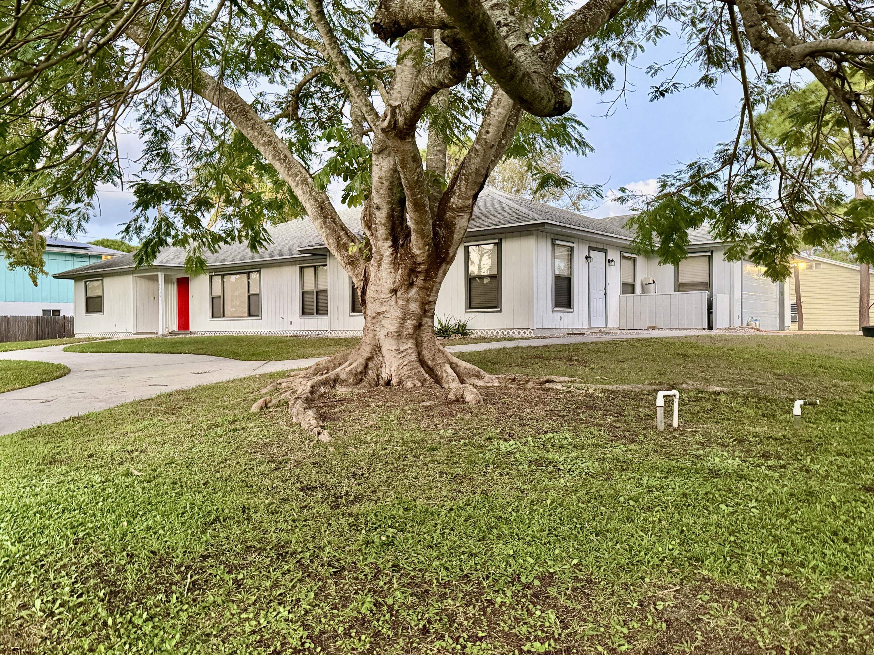 6539 Southeast Held Court Stuart, FL 34997 - Photo 34 of 34 a white house that has a tree in front of it