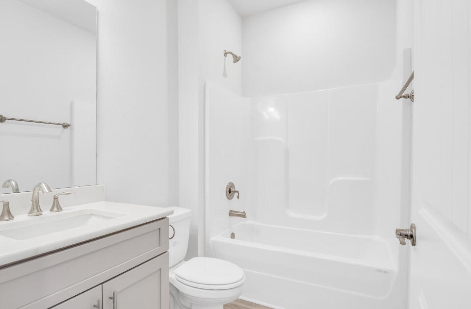 593 Alleyoak Lane, Unit 102 Freeport, FL 32439 - Photo 12 of 17 a bathroom with a granite countertop sink a toilet and shower