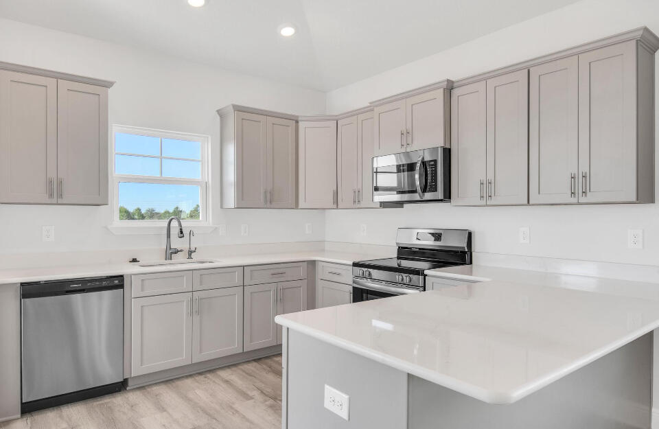 593 Alleyoak Lane, Unit 102 Freeport, FL 32439 - Photo 5 of 17 a kitchen with white cabinets sink and stainless steel appliances