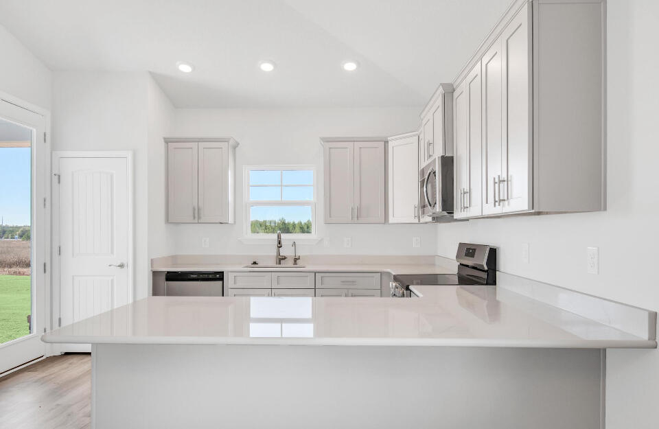 593 Alleyoak Lane, Unit 102 Freeport, FL 32439 - Photo 6 of 17 a large white kitchen with granite countertop a sink white cabinets and a granite counter tops