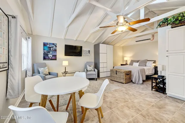 a living room with furniture a flat screen tv and a large window