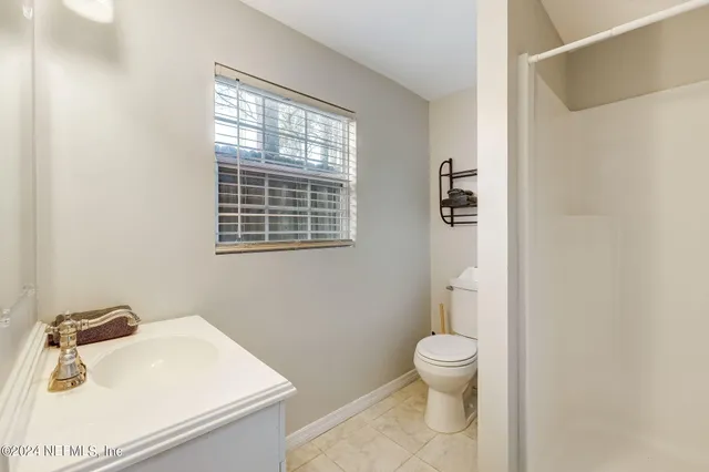 a bathroom with a sink toilet and a window